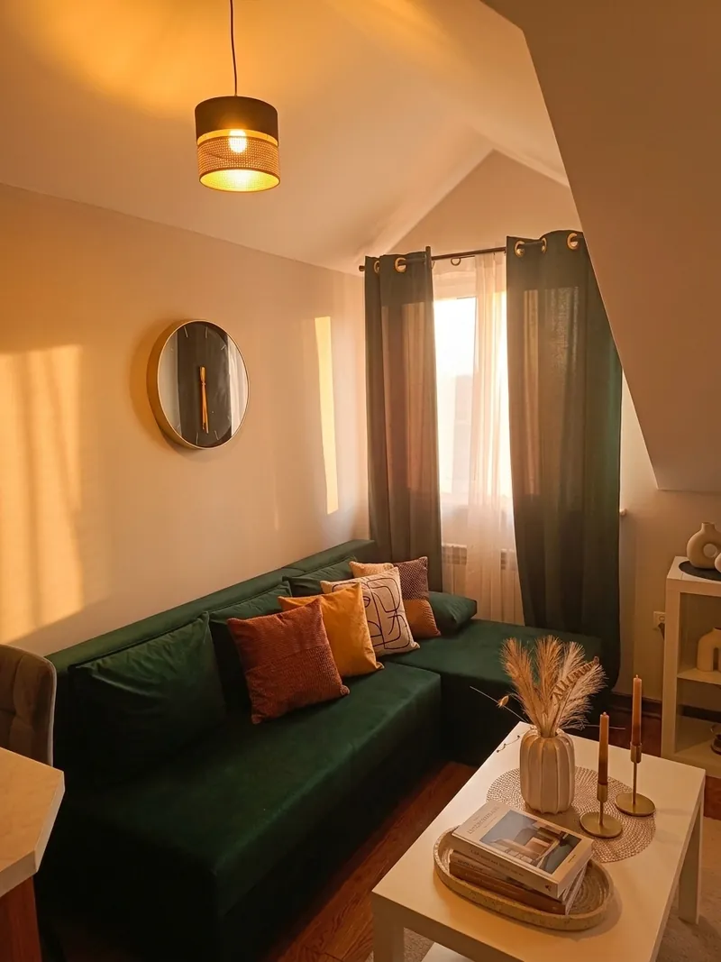 Studio: zielona sofa z poduszkami i stolik